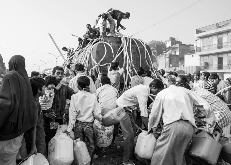 Women, men and children rushing to secure their share in the tanker water supply in South-East District, National Capital Territory of Delhi